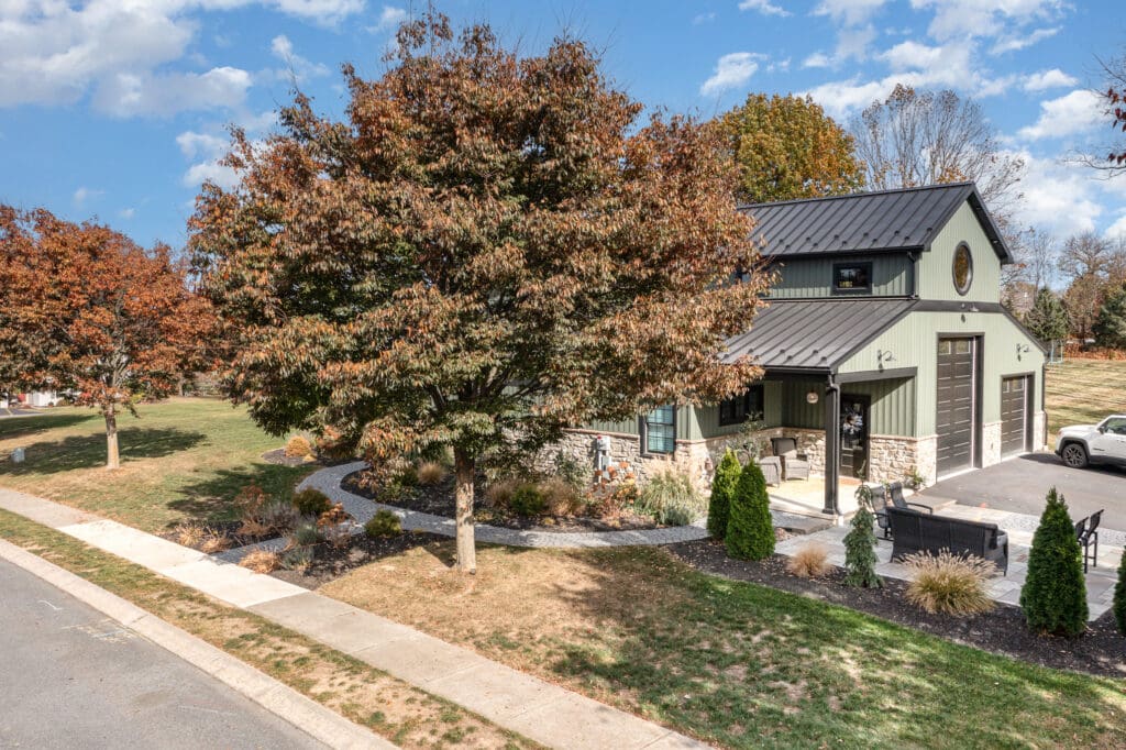 A home with a large tree in front, and a lawn that needs some care